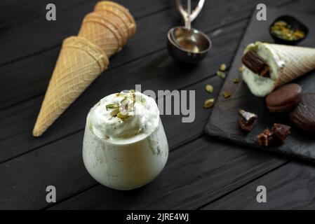 Glace à la pistache maison sur fond sombre. Ingrédients pour faire de la crème glacée sur un fond en bois Banque D'Images