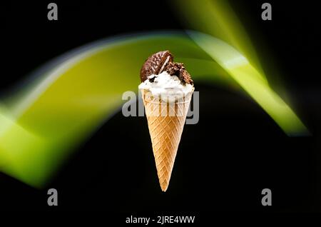Biscuits faits maison et crème glacée au cône de crème, sur un fond sombre avec une ligne verte abstraite en arrière-plan Banque D'Images