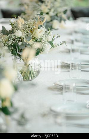 Table de réception de mariage dans le restaurant décoré de bougies blanches et de fleurs. Banque D'Images