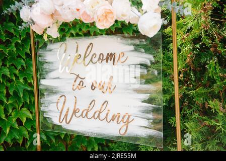 Pointeur de signalisation vierge sur un chevalet en bois dans un cadre avec couronne. Inscription de bienvenue Forest Wedding. Banque D'Images