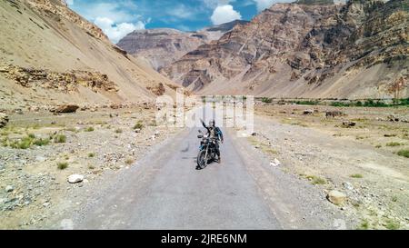 Homme en voyage moto aventure à travers Spiti Valley Inde le jour ensoleillé d'été entouré par des montagnes extrêmes Banque D'Images