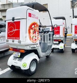 Une photo arrière de trois motos de livraison de 3 roues de mobilité Scooter Balance pour pizza Salvatore avec des toits garés dans un parking. Banque D'Images