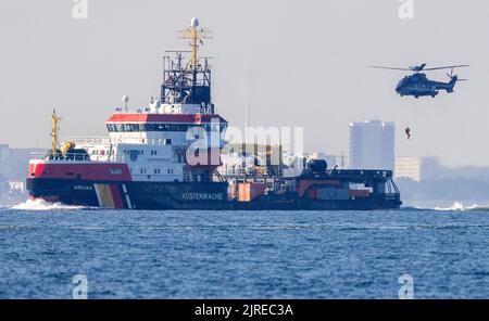 24 août 2022, Mecklembourg-Poméranie occidentale, Warnemünde: Des forces d'urgence sont déposées d'un hélicoptère sur le navire polyvalent 'Arkona' au-dessus de la mer Baltique dans le cadre de l'exercice environnemental 'Balex Delta'. Un déversement de pétrole est simulé au cours de l'exercice international au large de Warnemünde. Au cours de l'exercice à grande échelle, qui a lieu chaque année, les forces d'urgence des pays de l'UE riverains de la mer Baltique répètent le cas d'urgence avec plus de 15 navires spéciaux et 400 membres du personnel d'urgence. Photo: Jens Büttner/dpa Banque D'Images