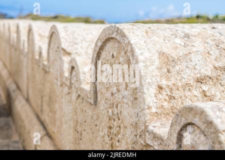 Une clôture en pierre calcaire ou une frontière décorée de petites et grandes arches en pierre autour de la chapelle Saint Dimitri dans le village rural de Gharb, Gozo, Malte Banque D'Images