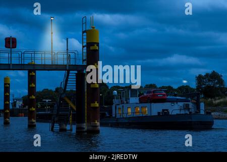 Une barge chargée de charbon se dirige vers l'écluse de Langwedel au milieu du Weser dans la soirée. Banque D'Images