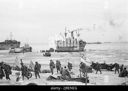 Troupes à terre sur l'une des plages de Normandie, passé le pavillon blanc de la marine une partie de plage, 7 juin 1944. D-Day, le 6 juin 1944 : le pavillon blanc de la Marine parti une plage sur la côte normande que les troupes britanniques vers l'intérieur des terres à partir de la sec, les engins de débarquement. Banque D'Images