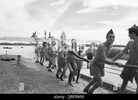 L'équipe de terrain de la RAF et les Singhalois locaux ont abaissé une Catalina consolidée de l'Escadron no 240 de la RAF dans l'eau du lac Red Hills, à Ceylon, après avoir subi des réparations, le 4 août 1945. Banque D'Images