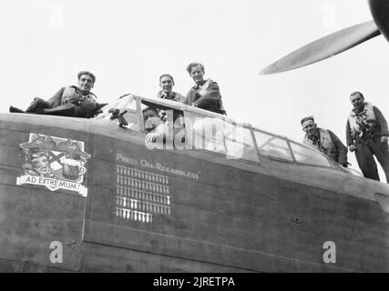 Royal Air Force Bomber Command, 1942-1945. L'équipage de l'Avro Lancaster B Mark III, ED905 'BQ-F' 'Appuyez sur sur peu importe', de No 550 Squadron RAF, posent sur leurs avions après avoir effectué 70 sorties opérationnelles, à North Yorkshire, Killinghome. Ils étaient à voler ED905's centième sortie réussie le 4 novembre 1944. L'équipage était composé de : Capitaine et pilote, le Lieutenant D'UN Shaw ; navigator, le sergent R Harris, ingénieur, officier pilote C Bruce ; air Flight-Sergeant Llanwarne bomber, UN ; mitrailleur dorsal, un Flight-Sergeant ; Buckingham et mitrailleur arrière, Flight-Sergeant E Griffiths. Banque D'Images