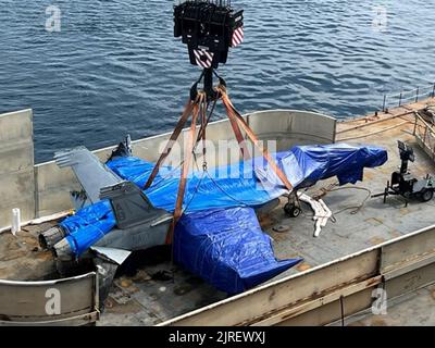 Vue d'un F/A-18E Super Hornet, pris sur 16 août 2022, au large de la côte de la Sicile, Italie, comme il est abaissé sur le grand navire de transport à vitesse moyenne du commandement militaire de Seallift, USNS Mendonca (T-AKR 303) pour le transport vers les États-Unis. L'avion, qui a été expulsé du porte-avions USS Harry S. Truman (CVN 75) par temps violent plus tôt cette année, a été récupéré à 9 500 pieds sous la mer Méditerranée à l'aide d'un VÉHICULE TÉLÉCOMMANDÉ CURV-21 pour attacher des lignes de levage et de gréage spécialisées à l'avion. Photo via U.S. Navy/UPI Banque D'Images