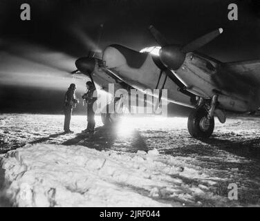 Royal Air Force- 2nd Tactical Air Force, 1943-1945. D'Adjudant Gosling (à gauche) et le chef d'escadron G H Hayhurst du No 604 Squadron RAF, sont devant leur Rafale marque NF XII dans la neige à B51/Lille-Vendeville, France, avant de décoller sur une sortie de chasse de nuit. Banque D'Images