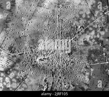 Royal Air Force- Opérations par les unités de reconnaissance photographique, 1939-1945. Photographie aérienne verticale de reconnaissance, prises à partir de 30 000 pieds, montrant le néant village de Aunay-sur-Odon, en Normandie, à la suite d'une attaque dévastatrice et très précis par Avro Lancaster du groupe no 5, le Bomber Command, dans la nuit du 14 au 15 juin 1944. Le raid a été monté à la hâte à la demande de la seconde armée, qui ont déclaré d'Aunay pour contenir les transports motorisés allemandes et des concentrations de troupes. Le seul bâtiment à rester debout pour jeter son ombre est dangereusement instable le clocher de l'église qui a été démo Banque D'Images