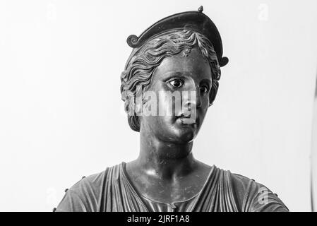 Photo en noir et blanc montrant en gros plan le visage de l'ancienne statue en métal représentant une jeune femme romaine avec un chapeau Banque D'Images