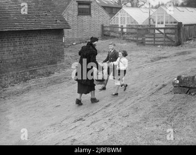 Les Carter en temps de guerre- la vie quotidienne d'une famille britannique sur le front intérieur, en Angleterre, C 1940 Michael et Angela Carter courir pour saluer leur mère à son arrivée à l'accueil des sinistrés à Hayward's Heath, dans le Sussex. Mme Carter a voyagé sur le train de Londres Victoria pour leur rendre visite. Banque D'Images