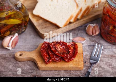 Tomates séchées à l'huile d'olive sur une mini-pension avec du pain maison dans un style rustique. Cuisine traditionnelle maison. Mise au point sélective, gros plan. Banque D'Images