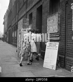 Les électeurs arrivant à un bureau de scrutin de l'hôpital italien, Queen Square, à Holborn, Londres d'exprimer leur vote dans l'élection générale de 1945. Trois jeunes femmes qui arrivent de bonne heure au bureau de scrutin pour voter à l'élection générale sur leur façon de travailler. Selon la légende originale,les bureaux de vote ouvrent à 7h et de rester ouvert jusqu'à tard dans la soirée. Ce bureau de vote est à l'hôpital italien sur Queen Square à Holborn. Banque D'Images