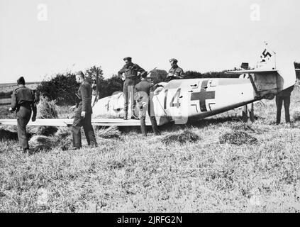 La bataille d'Angleterre 1940 officiers de l'inspection de l'épave du Messerschmitt Bf 109 E-1 (W.Nr. 3367) 'Red 14' de 2./JG52, qui a atterri en catastrophe dans un champ de blé à la ferme Mays, Selmeston, près de Lewes dans le Sussex, le 12 août 1940. Son pilote, l'Unteroffizier Leo Zaunbrecher, a été capturé. Banque D'Images