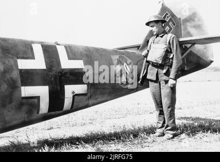 La bataille d'Angleterre, un membre de la Garde nationale se distingue par le fuselage arrière des Messerschmitt Bf 109 E-4 (W.Nr. 5587) '10' du 6./JG 51 'Mes dossiers', qui a atterri en catastrophe à Langdon est dans le Kent, 24 août 1940. Le pilote, l'Oberfeldwebel Beeck, a été capturé indemne. La Note II Gruppe emblèmes d'un oiseau pleureur avec un parapluie sous son aile et l'inscription 'Gott mitrailler l'Angleterre'. Banque D'Images