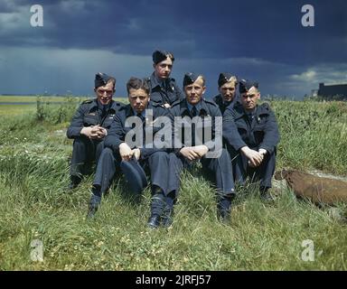 Le lieutenant de vaisseau Joe McCarthy (quatrième à partir de la gauche) et son équipage de l'escadron no 617 (les Dambusters) à la RAF Scampton, le 22 juillet 1943. L'équipage de Lancaster ED285/'AJ-T' assis sur l'herbe, s'est posé sous les nuages orageux. De gauche à droite : Sergent G Johnson; Officier pilote D A MacLean, navigateur; Lieutenant de vaisseau J C McCarthy, pilote; Sergent L Eaton, tireur. À l'arrière se trouvent le Sergent R Batson, tireur; et le Sergent W G Ratcliffe, ingénieur. L'officier de vol Dave Rodger, l'officier de bord arrière, est absent de la photo. Banque D'Images