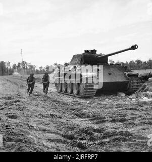 L'Armée britannique en Normandie 1944 hommes de la Durham Light Infantry, 49e Division (West Riding) 'avance' passé un frappé-out Panther allemand au cours de l'opération Epsom 'réservoir', 27 juin 1944. Banque D'Images