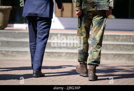 Munster, Allemagne. 24th août 2022. Stephan Weil (SPD, l), ministre-président de la Basse-Saxe, suit un chemin avec Lutz Kuhn, commandant de brigade de la Brigade d'entraînement de chars 9. Le Premier ministre parle avec le commandant de la brigade Lutz Kuhn et les soldats de la situation actuelle de la brigade. Credit: Philipp Schulze/dpa/Alamy Live News Banque D'Images