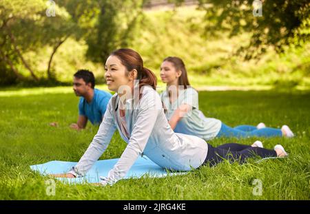 groupe de personnes faisant du yoga au parc d'été Banque D'Images