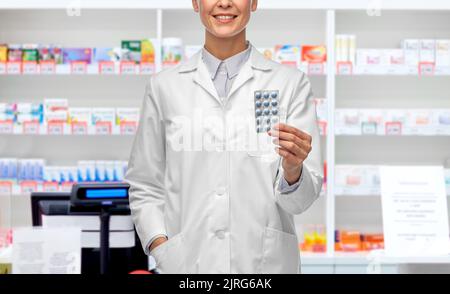 femme souriante médecin tenant des médicaments à la pharmacie Banque D'Images