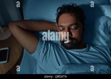 indien dormant au lit à la maison la nuit Banque D'Images