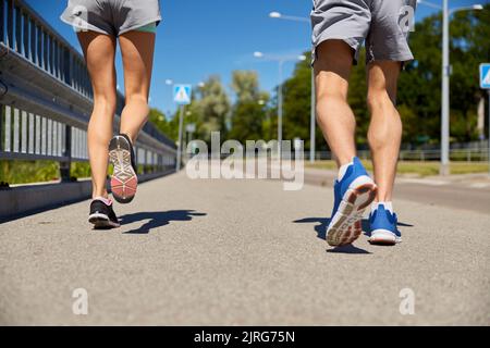 pieds de couple sportif en train de courir le long de la route de la ville Banque D'Images