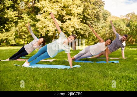 groupe de personnes faisant du yoga au parc d'été Banque D'Images