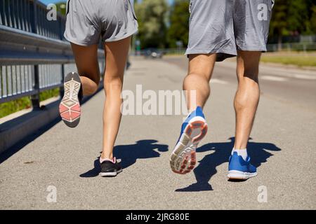 pieds de couple sportif en train de courir le long de la route de la ville Banque D'Images