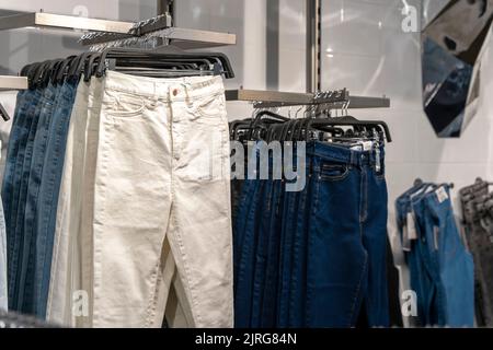 les jeans sont accrochés au comptoir dans un magasin de mode. des vêtements confortables Banque D'Images