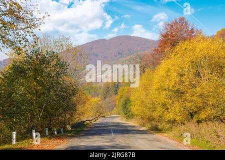 vieille route de montagne en automne. excursion à la campagne par une chaude journée ensoleillée. arbres en chemin dans un feuillage coloré Banque D'Images