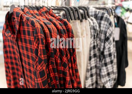 nouvelles chemises à carreaux avec manches courtes sur un cintre dans un magasin de vêtements Banque D'Images