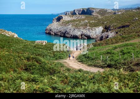 Les personnes marchant à la plage de San Antonio, une petite crique à quelques pas de Cuevas del Mar dans les Asturies, Espagne Banque D'Images