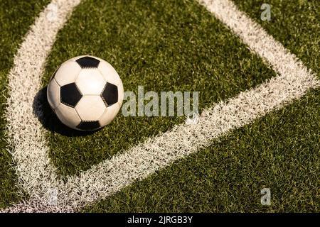 ballon de football blanc et noir sur fond d'herbe verte et de stade. idée de paris sportifs. Banque D'Images