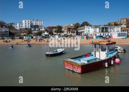 Les bateaux de pêche flottent dans la mer tandis que les gens apprécient le bon temps à Broadescaliers, dans le Kent, en Angleterre Banque D'Images