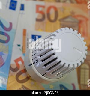 Thermostat devant les billets, symbolique des coûts de chauffage Banque D'Images