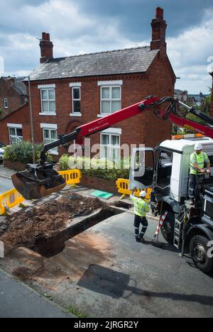 Une route en excavation par la compagnie d'eau United Utilities qui répare un tuyau souterrain à Barnton, Northwich Cheshire. Banque D'Images