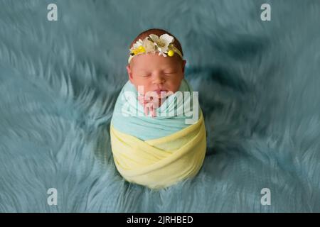 Enfant ukrainien nouveau-né dans le studio patriotique bleu jaune couleurs pendant la guerre en Ukraine 2022. Un petit bébé, une fille dort dans le cocon Banque D'Images