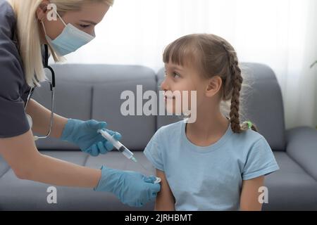 Peu de fille obtenant la vaccination de pédiatre à medical office Banque D'Images