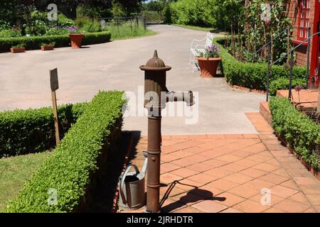 Une pompe à eau en métal rouillé sur le terrain d'une maison de campagne anglaise Banque D'Images