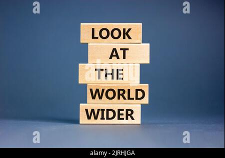Regardez le symbole du monde entier. Les mots de concept regardent le monde plus large sur des blocs de bois sur un beau fond gris de table. Business et look Banque D'Images