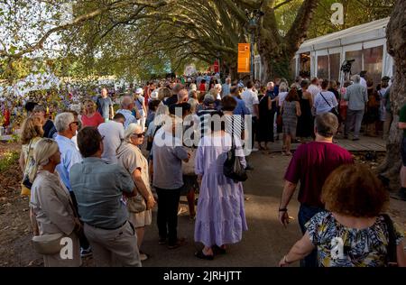 Ludwigshafen, Allemagne. 24th août 2022. Les visiteurs se tiennent à l'entrée du Festival du cinéma allemand de 18th. Le festival se déroule jusqu'à 11 septembre. Les organisateurs du festival présentent un total de 40 productions allemandes et 9 productions internationales, ainsi que 7 films pour enfants dans deux cinémas de tentes de 900 places chacun et un cinéma en plein air de 1200 places. Credit: Joachim Ackermann/dpa/Alay Live News Banque D'Images