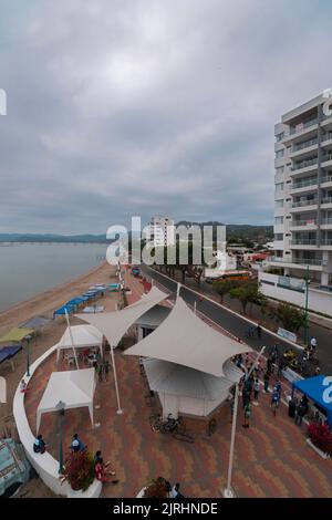 Bahia de Caraquez, Manabi / Equateur - 21 août 2022: Personnes marchant sur la promenade de la ville à côté de la plage par une journée nuageux Banque D'Images