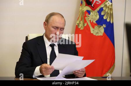 Novo-Ogaryovo, Russie. 24th août 2022. Le président russe Vladimir Poutine examine ses notes lors d'une réunion virtuelle avec les responsables des services d'urgence pour discuter de la réponse aux incendies de forêt dans tout le pays, depuis la résidence officielle de Novo-Ogaryovo, 24 août 2022 à l'oblast de Moscou, en Russie. Le temps chaud et sec a provoqué la propagation de feux de forêt dans les régions de Ryazan et Nizhny Novgorod et dans la République de mari El. Credit: Mikhail Klimentyev/Kremlin Pool/Alamy Live News Banque D'Images