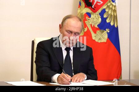 Novo-Ogaryovo, Russie. 24th août 2022. Le président russe Vladimir Poutine prend des notes lors d'une réunion virtuelle avec les responsables des services d'urgence pour discuter de la réponse aux incendies de forêt dans tout le pays, depuis la résidence officielle de Novo-Ogaryovo, 24 août 2022 à l'oblast de Moscou, en Russie. Le temps chaud et sec a provoqué la propagation de feux de forêt dans les régions de Ryazan et Nizhny Novgorod et dans la République de mari El. Credit: Mikhail Klimentyev/Kremlin Pool/Alamy Live News Banque D'Images