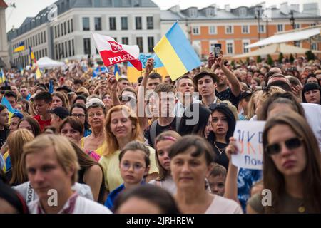 Les participants branle des drapeaux ukrainiens et polonais pendant la manifestation. Des milliers de réfugiés ukrainiens se sont rassemblés dans la vieille ville de Varsovie pour célébrer le jour de l'indépendance de l'Ukraine en 31st, le 24th août, et en même temps pour protester contre l'invasion russe de six mois qui a commencé le 24th février. Les organisateurs voulaient également rappeler au monde la guerre et exiger de la communauté internationale qu'elle reconnaisse officiellement la Russie comme un pays terroriste. L'événement a été organisé par le Centre international pour la victoire ukrainienne et l'organisation Euromaidan. Banque D'Images