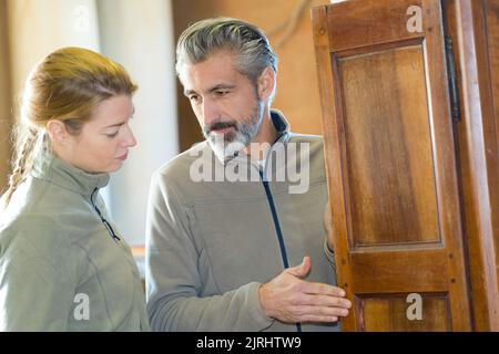 hommes et femmes travaillant à la porte de placard en bois Banque D'Images