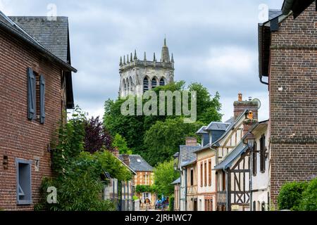 LE BEC-HELLOUIN, FRANCE - 26th MAI 2022 : vue sur une rue avec de vieilles maisons à colombages et la tour de l'abbaye. Banque D'Images