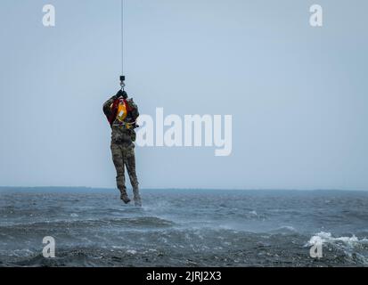 Un étudiant de survie, d'évasion, de résistance et d'évasion de l'aile des opérations spéciales de 492nd est hissé hors des eaux près de la base aérienne d'Eglin, en Floride, le 16 août. Les aviateurs ont terminé leur portion de survie en eau de l’entraînement du SERE avec l’aide du système de levage UH-1 Huey du 413th Flight Test Squadron. L'UH-1 a soulevé chaque étudiant hors de l'eau les hissant au fond de l'avion et en arrière. (É.-U. Photo de la Force aérienne/Samuel King Jr.) Banque D'Images